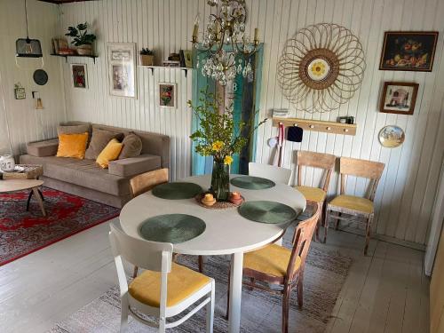 a living room with a table with chairs and a couch at Wiire old fishermans farmhouse and smoke sauna in Saulepa