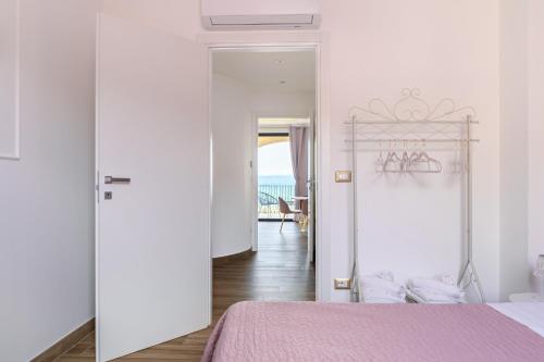 - une chambre avec un lit rose et une porte donnant sur l'océan dans l'établissement Casa Vacanze Maddalena - Palazzetto sul lago - Diamante Rosa, à Marta