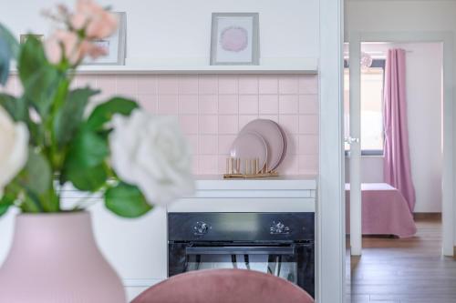 uma cozinha com lareira e uma parede de azulejos cor-de-rosa em Casa Vacanze Maddalena - Palazzetto sul lago - Diamante Rosa em Marta