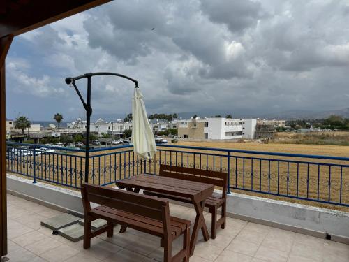 a table and bench on a balcony with an umbrella at Galtheo in Lachi