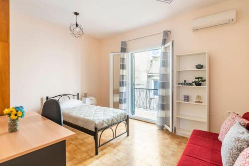 a living room with a bed and a balcony at Corfu Downtown in Corfu Town