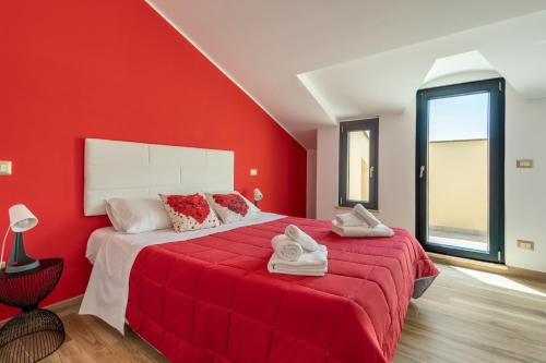 czerwona sypialnia z dużym łóżkiem z czerwonymi ścianami w obiekcie Rosso Rubino - Mansarda Vista Lago a Marta w mieście Marta