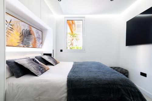 a white bedroom with a bed with two pillows at Apartamerica 341 LujoVista Mar in Playa de las Americas