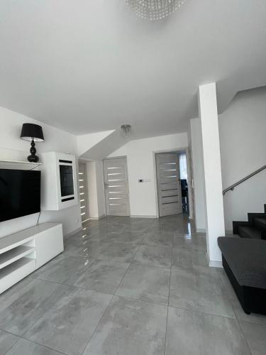 a living room with a television and a couch at Apartament pod Łebą in Charbrowo