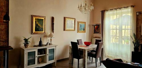 uma sala de jantar com uma mesa e cadeiras e um lustre em Casa Rivoluzione (da Elvira) em Palermo