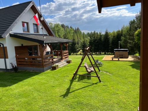 Domek z kominkiem nad jeziorem z jacuzzi ogrodowym