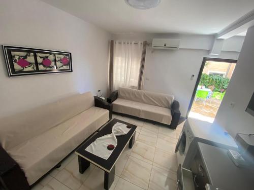a living room with a couch and a table at Olive Tree Apartment in Sarandë