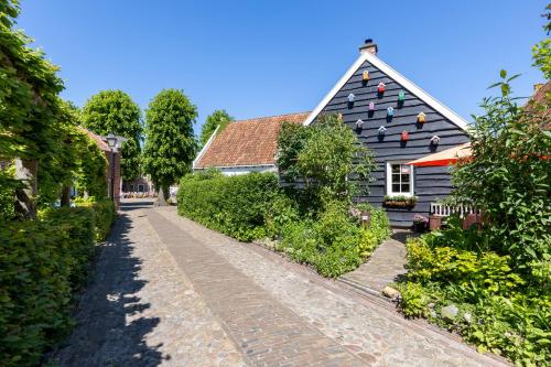 a house with a black roof and a brick road at Ster van Bourtange in Bourtange