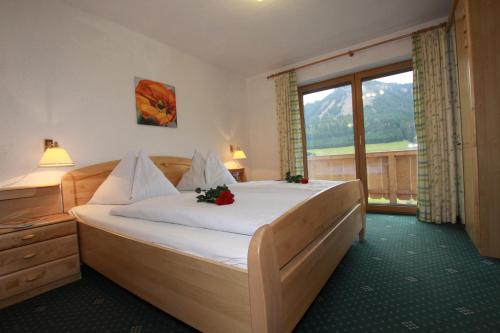 a bedroom with a large bed with flowers on it at Haus Schöne Aussicht in Berwang