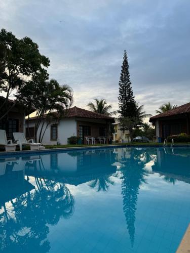 ein Swimmingpool vor einem Haus in der Unterkunft Bangalô 5 - Praia de Guaratiba-prado/ba in Prado