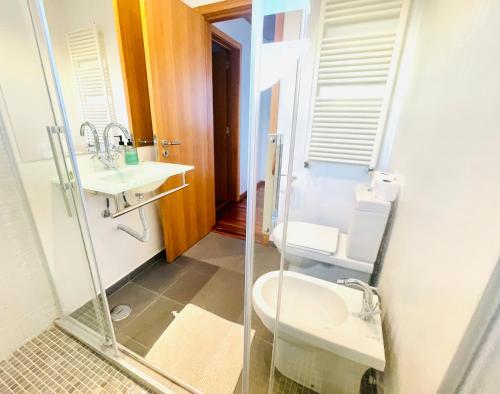 W łazience znajduje się umywalka, toaleta i lustro. w obiekcie Vila D'Alba - Sem Stress w Albufeirze