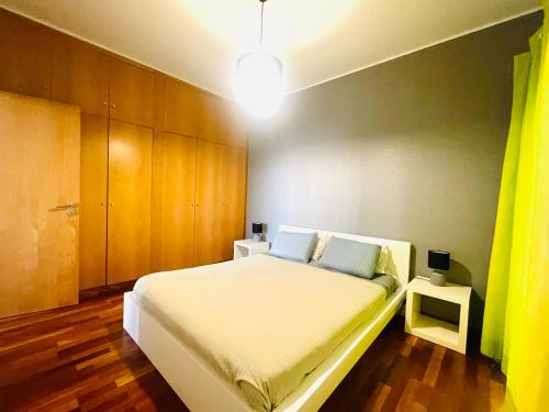 sypialnia z białym łóżkiem i drewnianymi szafkami w obiekcie Vila D'Alba - Sem Stress w Albufeirze