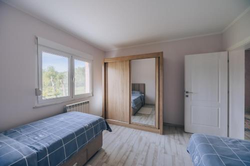 1 dormitorio con 2 camas y espejo en Apartment Majstorina en Virpazar