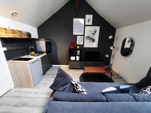 un salon avec un canapé bleu et une cuisine dans l'établissement Le Perdrix : Apt 2 prs, proche Gare et Darcy, à Dijon