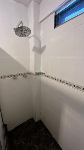 a bathroom with a shower with a light and a window at Hotel Espindola in Tulcán