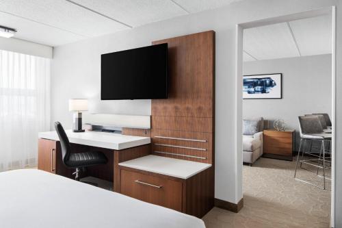 a hotel room with a desk and a tv on a wall at Delta Hotels by Marriott Green Bay in Green Bay