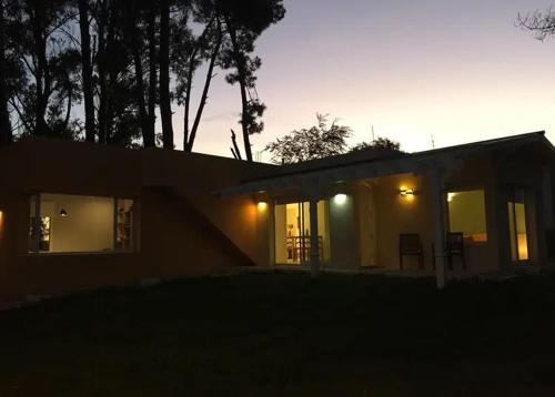 una pequeña casa con las luces encendidas por la noche en Refugio Zen, en Sierra de los Padres