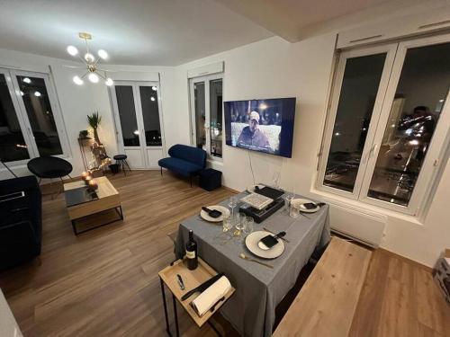 a living room with a table in the middle of it at Beautiful appartement with perfect location in Épernay