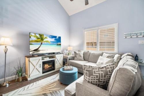 a living room with a couch and a tv at Steps 2 beach Ocean view Pool Parking in Brigantine