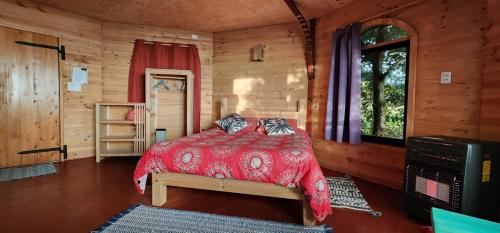 a bedroom with a bed in a log cabin at HOSTAL TORRE DEL ESPAÑOL in Valdivia