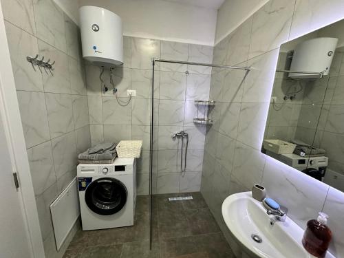 a bathroom with a washing machine and a sink at Luxury Apartment with Parking in Tirana