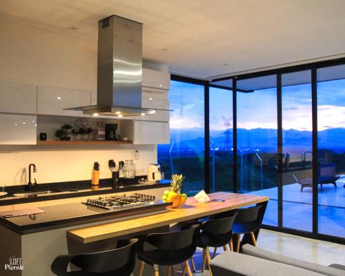 a kitchen with a counter with a view of the mountains at LoftMerak in Pereira