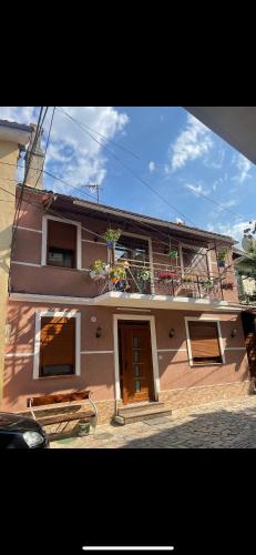 a building with a balcony with plants on it at Topleci Guest House in Pogradec