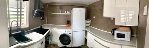 cocina con lavadora y microondas en Puig comfort en Calella