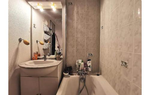 La salle de bains est pourvue d'un lavabo et d'une baignoire à côté d'un lavabo. dans l'établissement Chambre chez l'habitant tout confort aux Balcons de Bigorre, à Tarbes