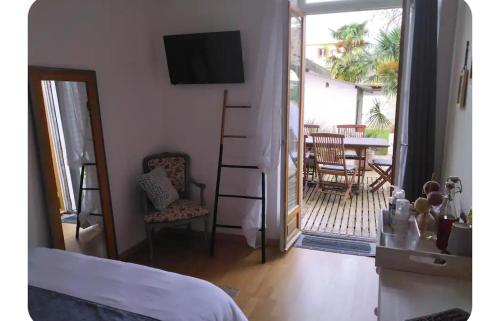 une chambre avec un lit et un balcon avec une table dans l'établissement Chambre chez l'habitant tout confort aux Balcons de Bigorre, à Tarbes