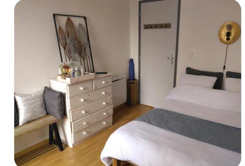 - une chambre avec une commode, un lit et une commode dans l'établissement Chambre chez l'habitant tout confort aux Balcons de Bigorre, à Tarbes
