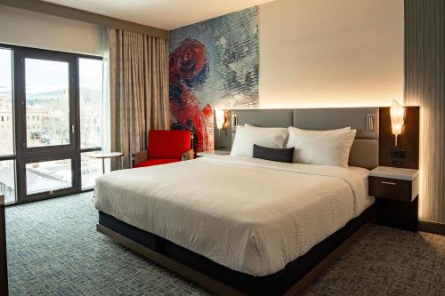a hotel room with a bed and a red chair at Hotel 43 Boise in Boise