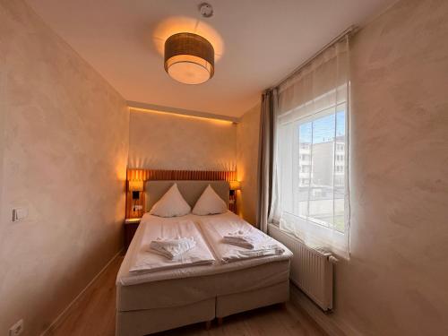 a small bedroom with a bed and a window at dingdong bonn - city apartments in Bonn