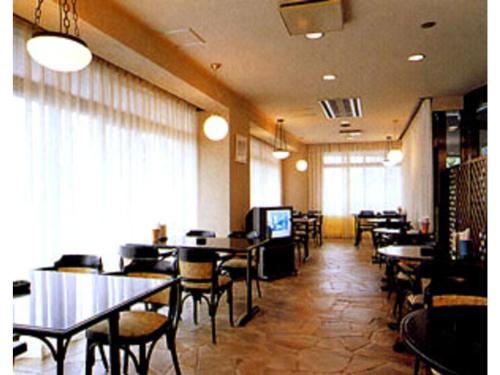 a dining room with tables and chairs in a restaurant at Kumegawa Wing Hotel - Vacation STAY 62973v in Higashi-murayama