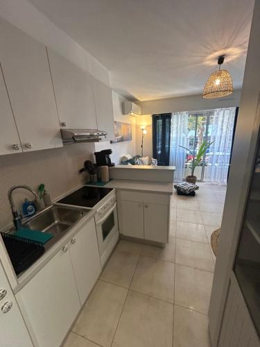 une cuisine avec un évier et une cuisinière four supérieur dans l'établissement Studio Emeraude à Cavalaire, à Cavalaire-sur-Mer
