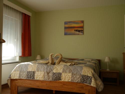 a bedroom with a bed with a comforter with two snakes on it at Ferienhaus-Uckermarkblick in Rosenow