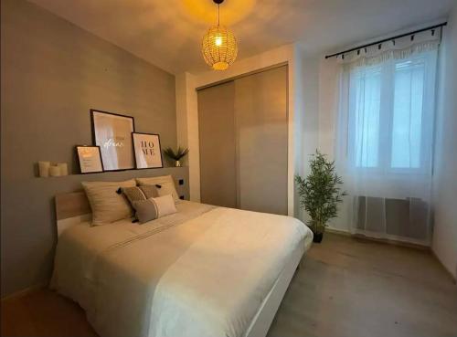 une chambre avec un grand lit blanc avec une fenêtre dans l'établissement La Belle Échappée, à Lourdes