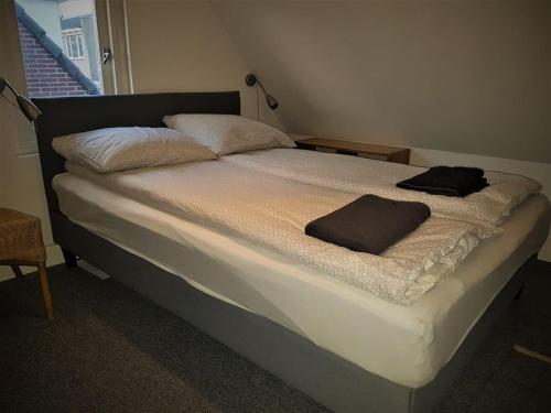 a bed in a room with two towels on it at Have a nice stay! - Beach Cottage free parking in Noordwijk aan Zee