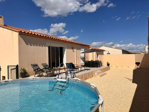 een zwembad met stoelen en een huis bij Lion house in Saint-Gilles