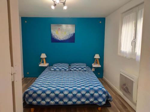 - une chambre bleue avec un lit et deux lampes dans l'établissement Bienvenue chez vous, à Honfleur
