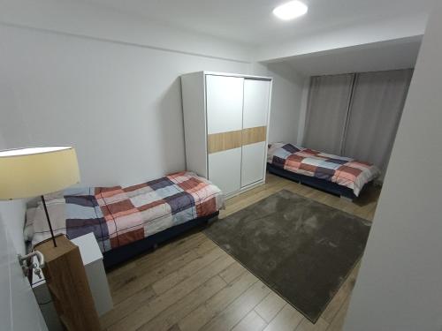 Grand Apartments Strumica في ستروميكا: غرفة نوم صغيرة مع سريرين وخزانة