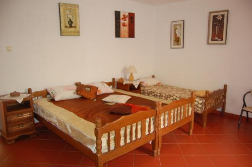 two twin beds in a room with a table and a bed at Vila Montenegro in Dobra Voda