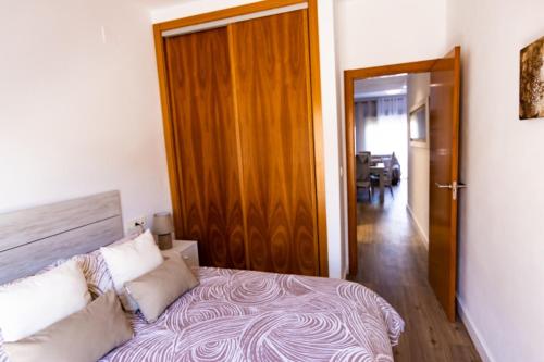 1 dormitorio con 1 cama y puerta de madera en Que vistas, en Granada