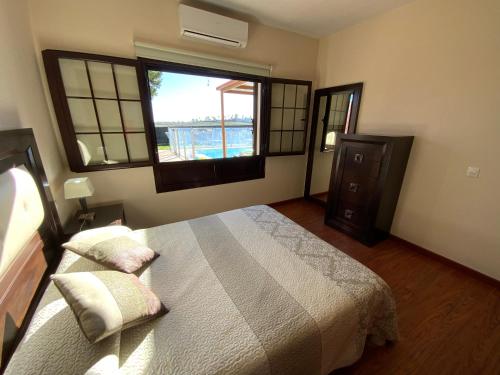 a bedroom with a bed and a large window at Villa Abuelo Paco - Private heated pool in Playa Blanca
