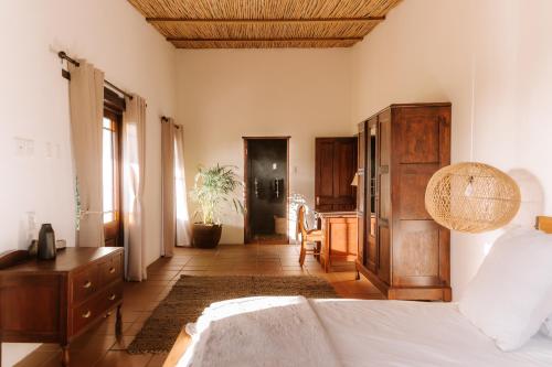a bedroom with a bed and a wooden ceiling at Worlds Apart - River Front Guest Farm & Camping in Bonnievale