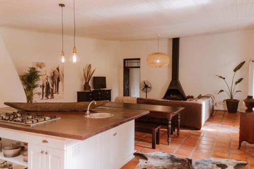 a kitchen and living room with a stove and a couch at Worlds Apart - River Front Guest Farm & Camping in Bonnievale