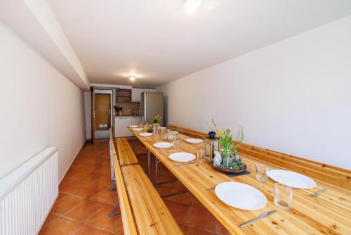 a long wooden table with white plates on it at Apartmani Anđelić- Fužine 1 in Fužine