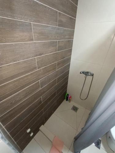 y baño con ducha de azulejos grises. en Grand Apartments Strumica, en Strumica