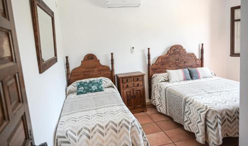 a bedroom with two beds and a mirror at Amplia casa rural con precioso jardín cerca de Málaga capital. in Málaga