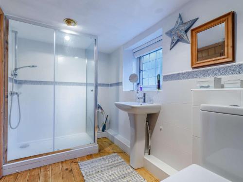 ein Bad mit einer Dusche und einem Waschbecken in der Unterkunft 3 Bed in Fritchley 85797 in Crich